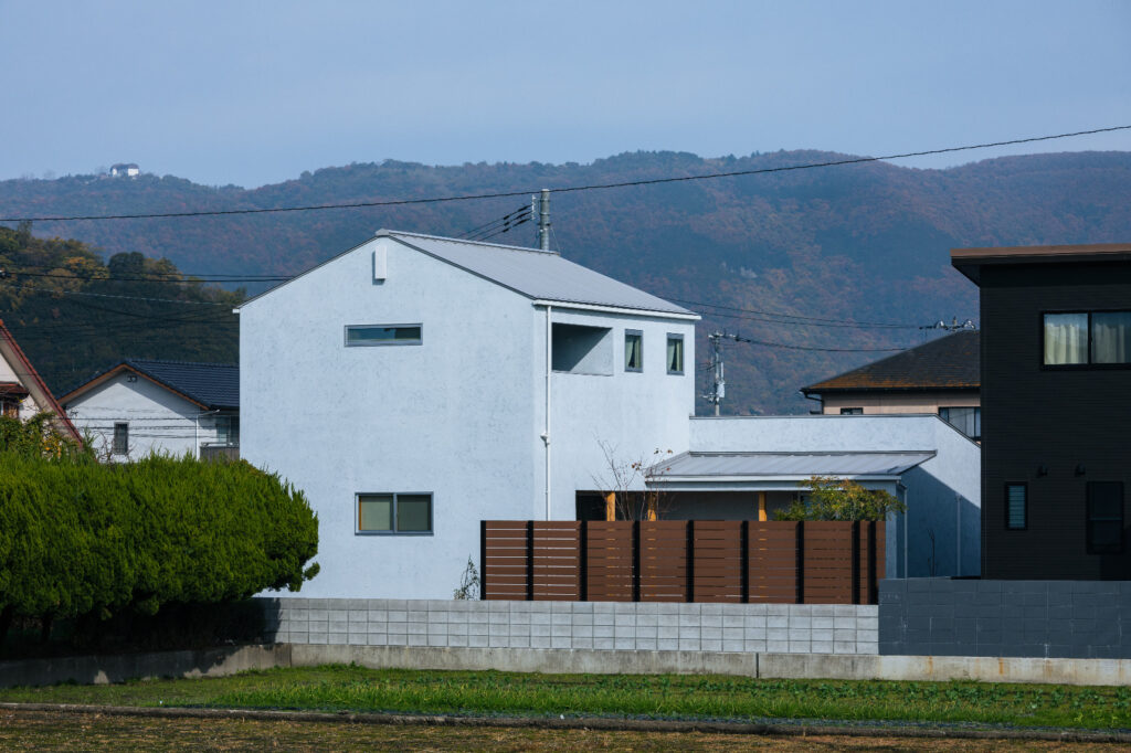 空間をつなぐL字型デッキの家
